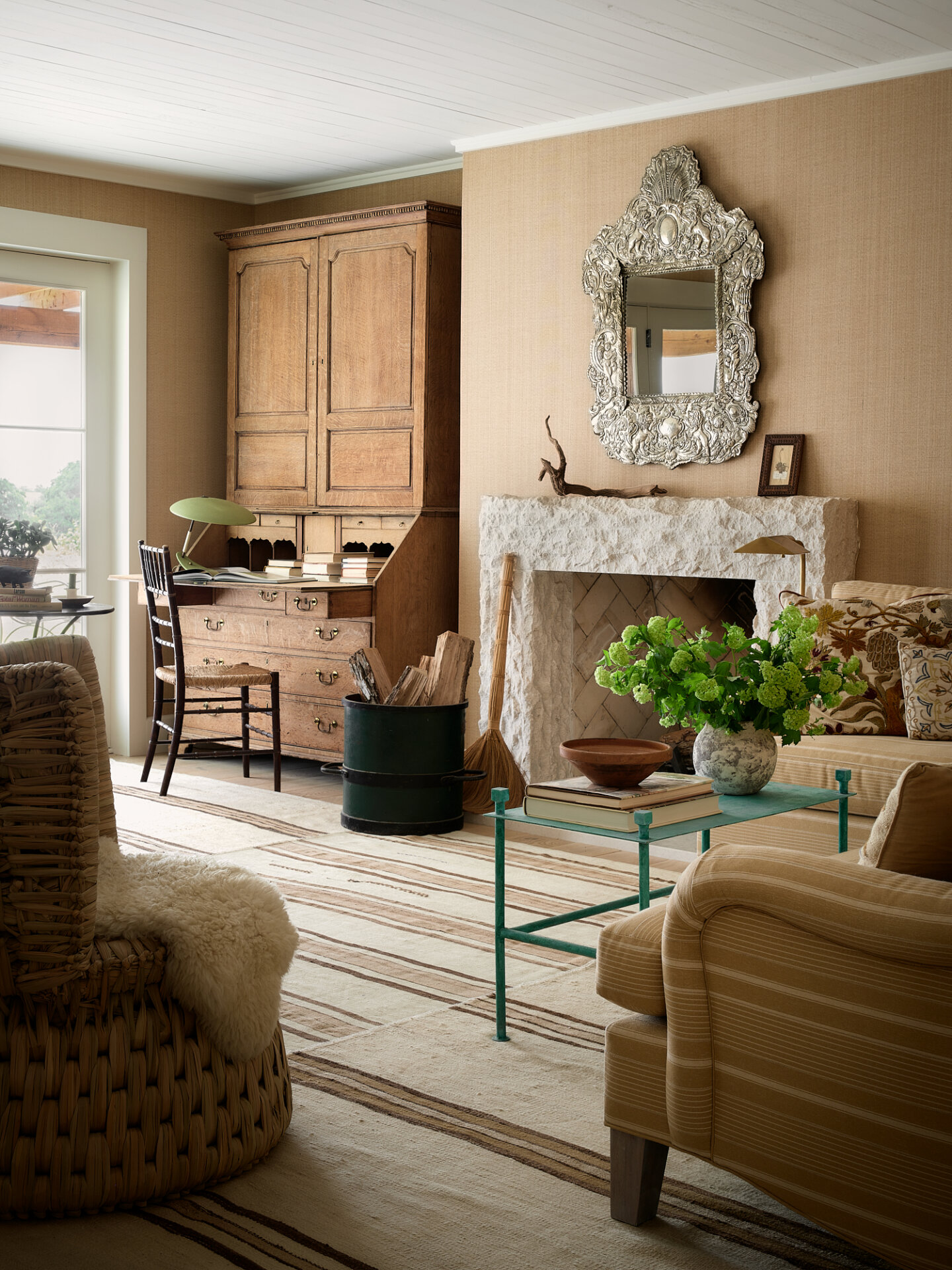 Elegant living room with fireplace, vintage mirror, and cozy furniture.