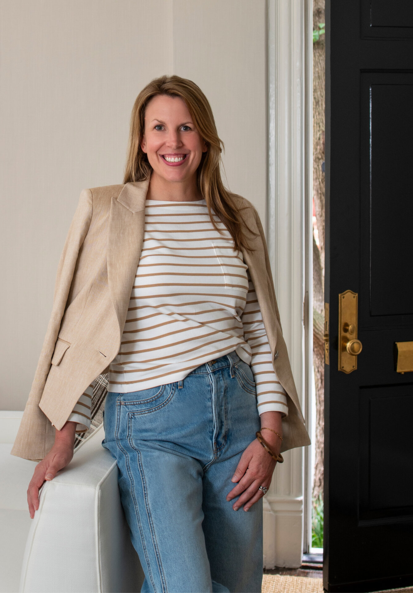 Melissa in casual outfit standing by a door at Melissa Lacy Design.